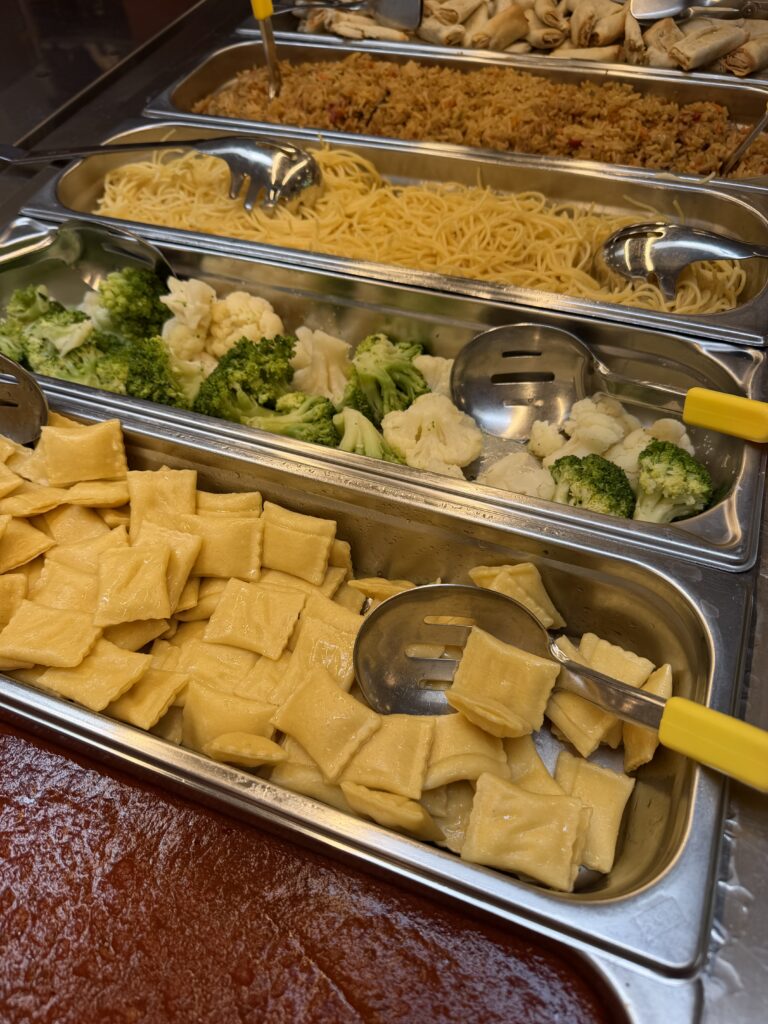 Mittagsbuffet mit verschiedenen warmen Speisen und Gemüse